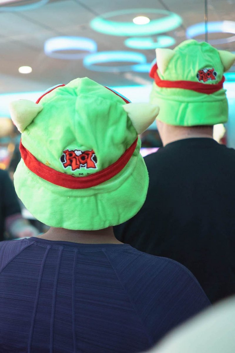 A Picture of people with green Riot hats from the back